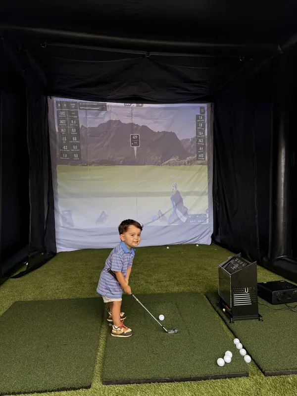 A child taking a swing inside the simulator bay