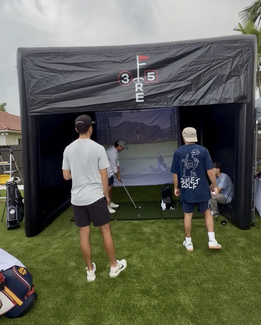 The inflatable bay set up on a back lawn with guests waiting to hit