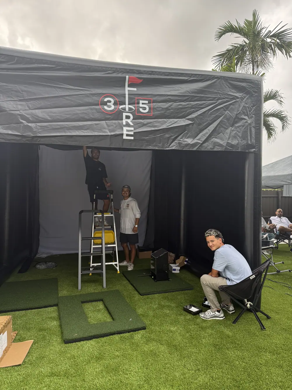 The simulator set up outdoors under a black canopy with guests standing around it