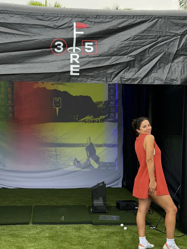 A guest standing in front of the lit simulator screen at an evening event