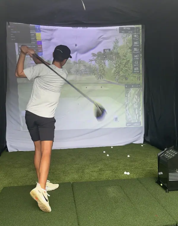 A guest at the top of the backswing inside the bay