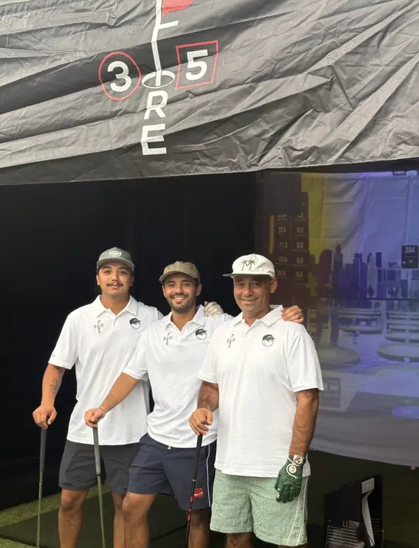 The three-person 3Fore5 crew under the branded canopy